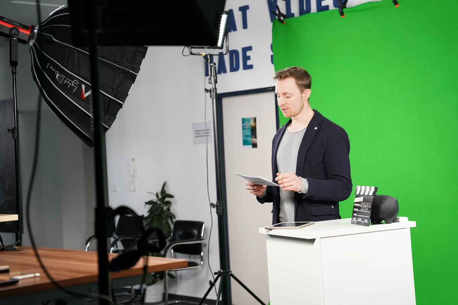 Moderation am Pult vor dem Green Screen
