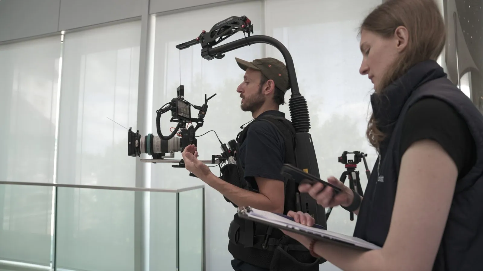videoboost-Kameramann mit Cinema-Rig auf Easyrig und Aufnahmeleitung bei einem Dreh