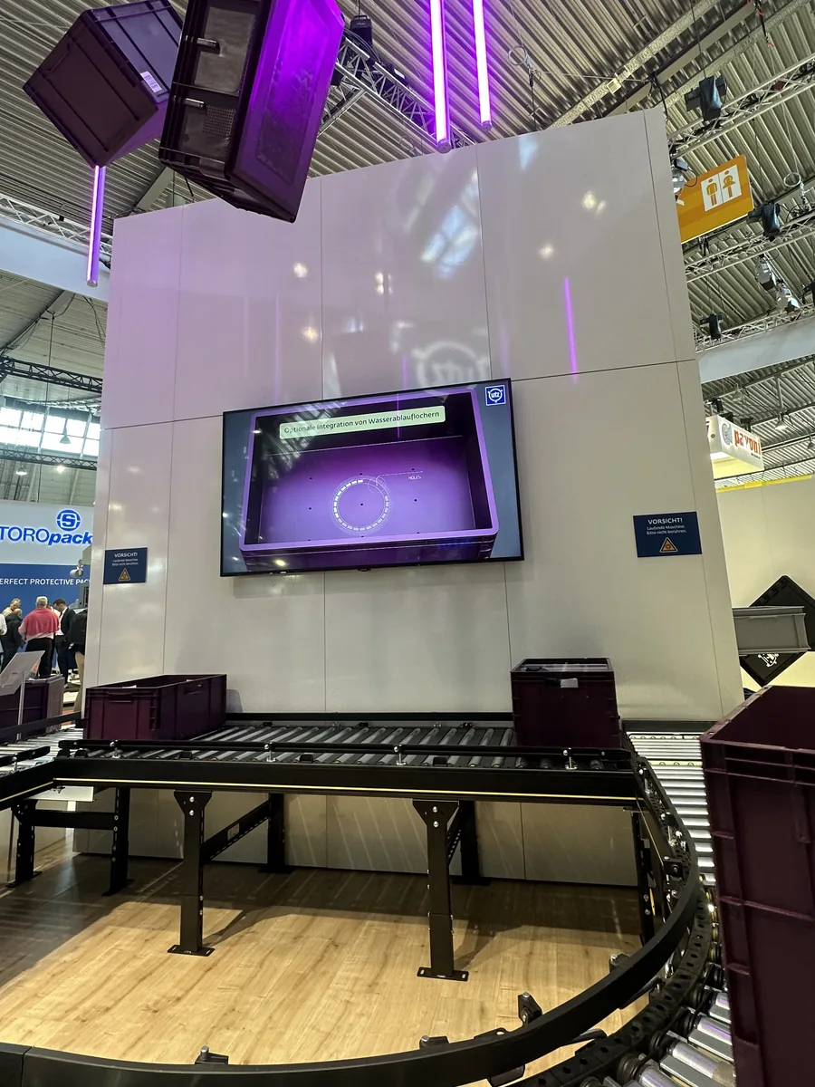 Georg-Utz-Stand auf der LogiMAT mit hängenden Behältern, Fördertechnik und Bildschirm