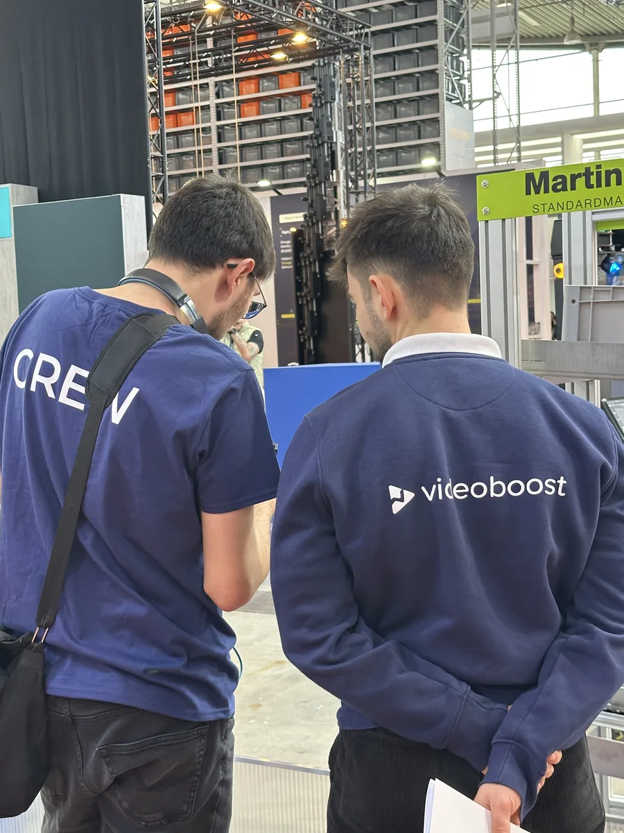 videoboost-Crew beim Messedreh auf der LogiMAT, Blick auf den Monitor am Stand
